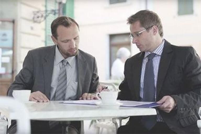 2 people in suits having meeting
